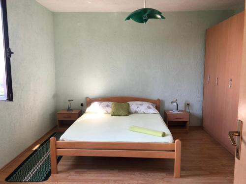 a bedroom with a bed with a green lamp above it at Apartment JELENA in Senj