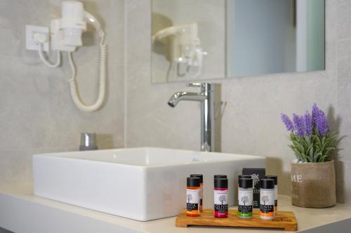 a bathroom sink with four bottles of essential oils at Athina Suites Platanias in Plataniás
