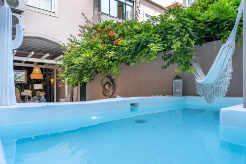 a swimming pool with a hammock next to a building at Garam Lisboa in Lisbon