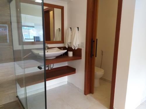 a bathroom with a sink and a glass shower at Pousada e Restaurante O Pescador in Abraão