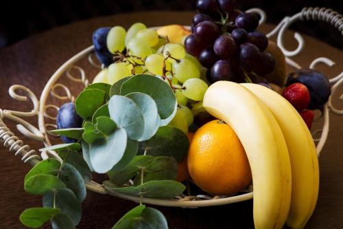 a basket of fruit on a wooden table at Hotel Selsky Dvur - Bohemian Village Courtyard in Prague