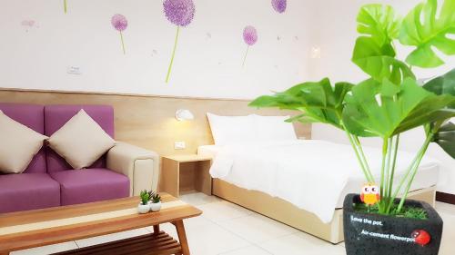 un salon avec un canapé violet et une plante dans l'établissement Wei Yu No.1, à Tainan