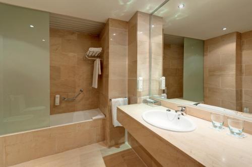 a bathroom with a sink and a bath tub at Hotel Ceuta Puerta de Africa in Ceuta