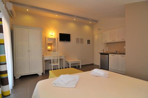 a room with two beds and a kitchen with a table at Ntinas Filoxenia Hotel & Spa in Skala Potamias