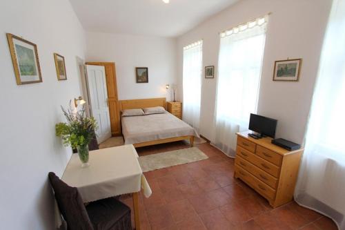 a room with a bedroom with a bed and a desk at Penzion Jelen Vranov nad Dyjí in Vranov nad Dyjí