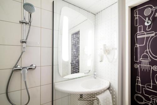 a bathroom with a sink and a shower at Ibis Schiphol Amsterdam Airport in Badhoevedorp