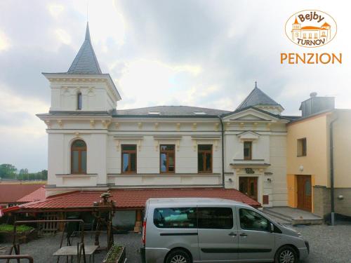a van parked in front of a building with a church at Penzion Bejby Turnov in Turnov
