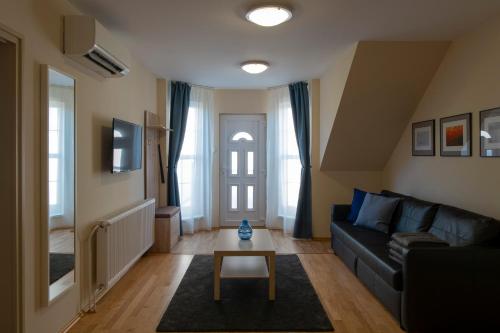 a living room filled with furniture and a window at Airport Apartman in Vecsés