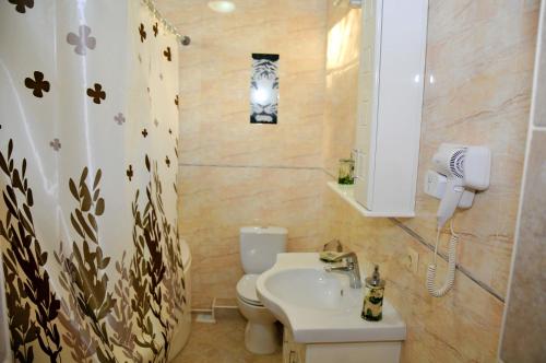 a bathroom with a sink and a toilet and a mirror at Totem Hotel in Shymkent