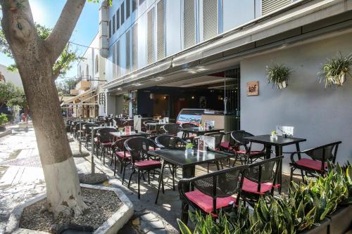 a row of tables and chairs in front of a building at Capsis Astoria Heraklion in Heraklio Town