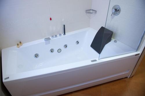 a white bath tub with a black umbrella on it at Artemis Hotel in Cefalù