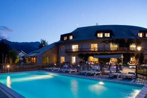 un hôtel avec une piscine devant un immeuble dans l'établissement La Villa d'Emma, à Embrun