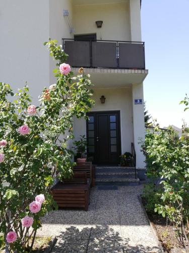 a house with a black door and pink roses at Ferienwohnung AOLI in Gmunden