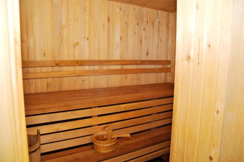 an empty wooden sauna with a bucket in it at Totem Hotel in Shymkent