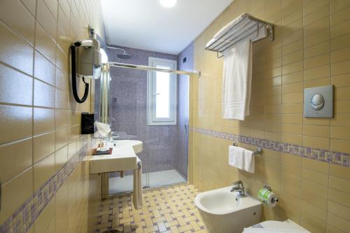 a bathroom with a sink and a toilet at Artemis Hotel in Cefalù