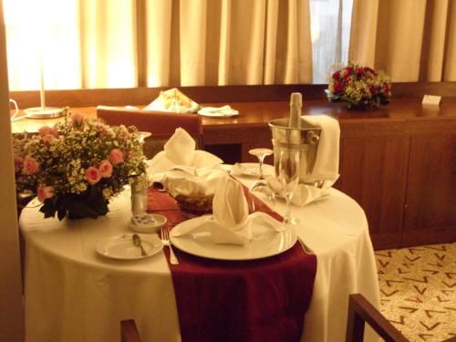 a table with a white table cloth and flowers on it at Skyna Hotel Luanda in Luanda