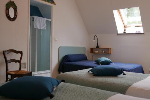 una camera da letto con due letti, una sedia e una finestra di Les Chambres du Moulin a Susmiou