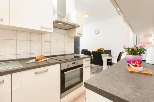 eine Küche mit weißen Schränken und einer Arbeitsplatte in der Unterkunft Marasovica Apartments in Split