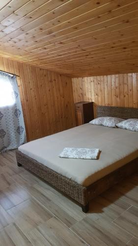 1 dormitorio con 1 cama en una habitación de madera en Casa la Petcu, en Costinesti