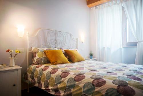 1 dormitorio con 1 cama grande con almohadas amarillas en Sottocastello Il Casale en Osimo