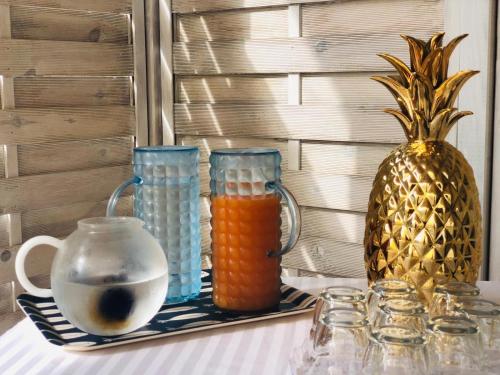 a table with two blue glass vases and a pineapple at Villa dei Ginepri in Gallipoli