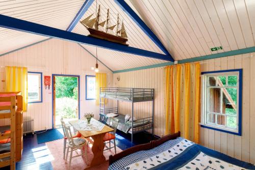 a bedroom with a bed and a table in a room at Cirkus Hostel Holken in Inkoo