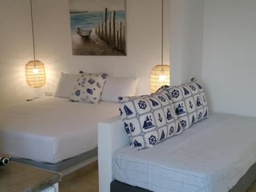 a living room with two beds and two lamps at Infinity Apartments in Naxos Chora