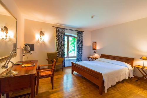a bedroom with a bed and a desk and a window at Hotel El Molino de Salinas in Salinas de Pisuerga