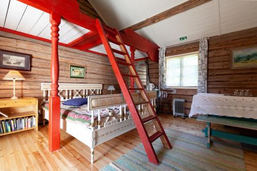 sypialnia z czerwonym łóżkiem piętrowym i drabiną w obiekcie Cirkus Hostel Holken w mieście Inkoo