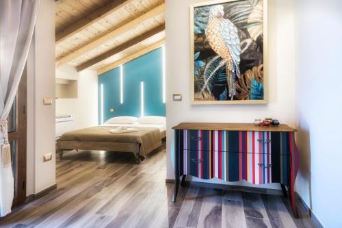 a bedroom with a bed and a painting on the wall at Palazzo Eugenia Suites in Vasto