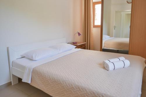 a white bed with two rolls of towels on it at Kazanegra Exclusive Apartments in Sveti Stefan