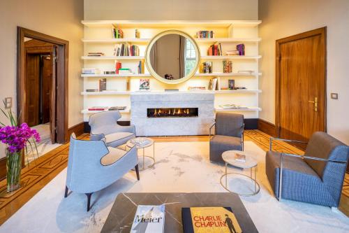 a living room with a fireplace and a mirror at Fraser Suites Hamburg in Hamburg