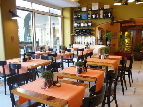 a restaurant with wooden tables and chairs and windows at Enjoy 1313AG Hotel Touring in Chiasso