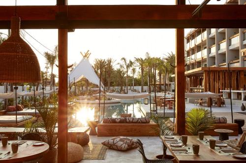 a view of a hotel with a pool and tables and chairs at The Syntopia Hotel - Adults Only in Adelianos Kampos