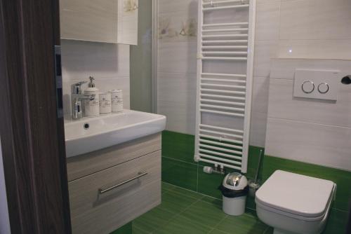 a bathroom with a white sink and a toilet at Chata Diana in Vítkovice