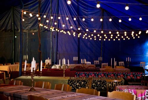 een blauwe tent met tafels, stoelen en verlichting bij Cirkus Hostel Holken in Inkoo