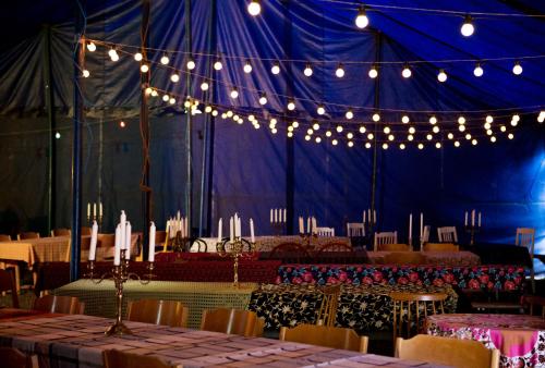 Tienda azul con mesas, sillas y luces en Cirkus Hostel Holken, en Inkoo