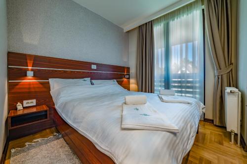 ein Schlafzimmer mit einem großen Bett mit Handtüchern darauf in der Unterkunft Vila Valentina in Zlatibor