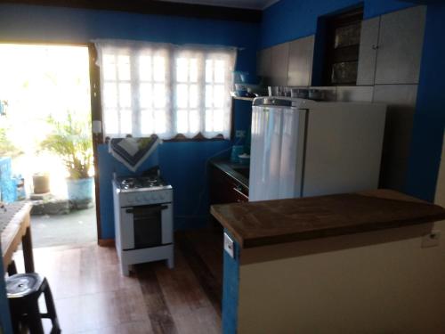 a kitchen with a white refrigerator and a stove at Chalé da Dô in Ilhabela