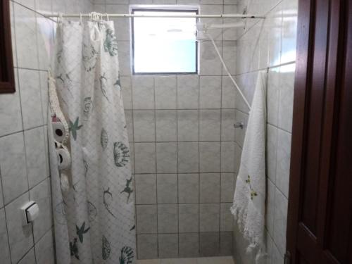 a bathroom with a shower with a shower curtain at Chalé da Dô in Ilhabela