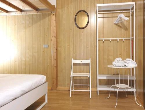 ein Schlafzimmer mit einem Bett, einem Tisch und einem Stuhl in der Unterkunft San Lorenzo Cozy Studio in Bergamo
