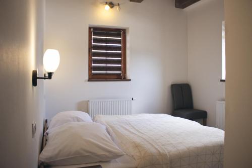 a bedroom with a bed and a window and a chair at Chata Diana in Vítkovice