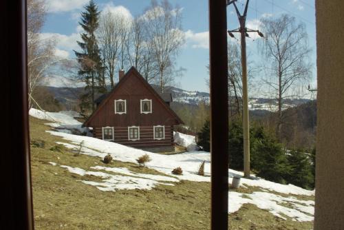 una ventana con vistas a una casa en la nieve en Chata Diana, en Vítkovice