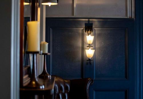 a room with a wall with two lights and a chair at Dunstan House in Burnham on Sea