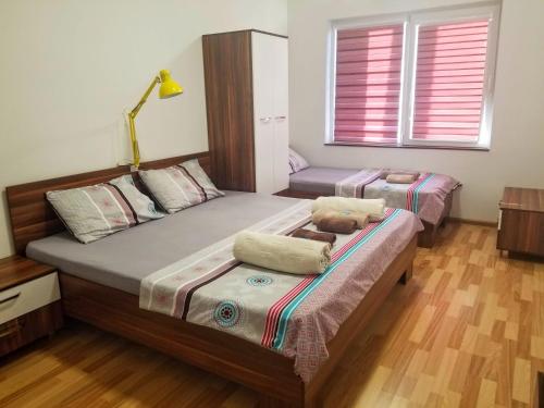 a bedroom with two beds and a lamp at Sky Apartments in Strumica