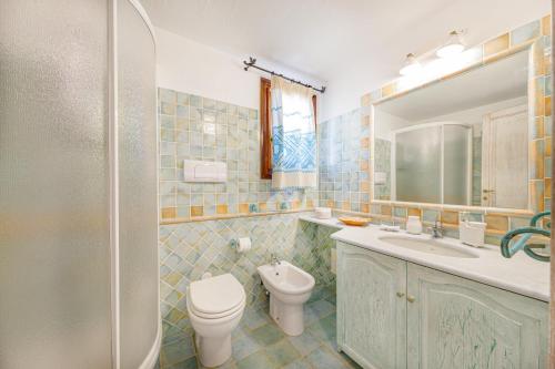 bagno con servizi igienici, lavandino e specchio di Villa con vista Porto San Paolo a Porto San Paolo
