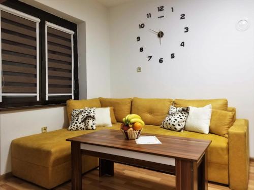 a living room with a couch and a table with a clock at Sky Apartments in Strumica