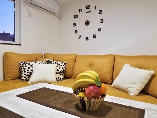 a room with a couch with a bowl of fruit on a table at Sky Apartments in Strumica