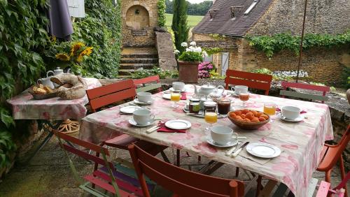 a table with a bowl of fruit on a patio at La vignolle in Saint-Amand-de-Coly