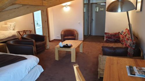 a hotel room with a bed and a table and chairs at Auberge de Savoie in Moutiers